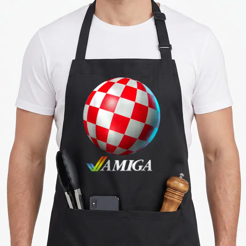 Tablier de cuisine noir avec une sphère à damier rouge et blanc et le logo AMIGA en bas.