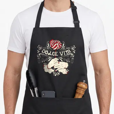 Tablier de cuisine noir avec illustration vintage de mains tenant un bonbon et le texte Dolce Vita en lettres blanches.
