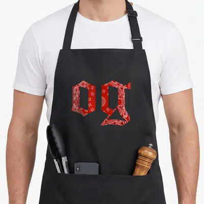 Tablier de cuisine noir avec les lettres OG stylisées en motif bandana rouge et blanc.