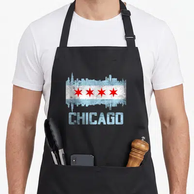 Tablier de cuisine noir avec skyline et drapeau de Chicago imprimé en bleu et rouge.