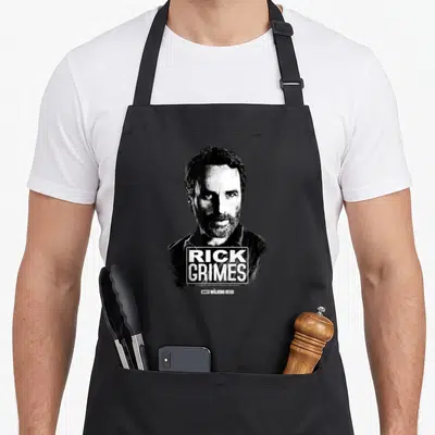 Tablier de cuisine noir avec le portrait de Rick Grimes et le logo Walking Dead en blanc.