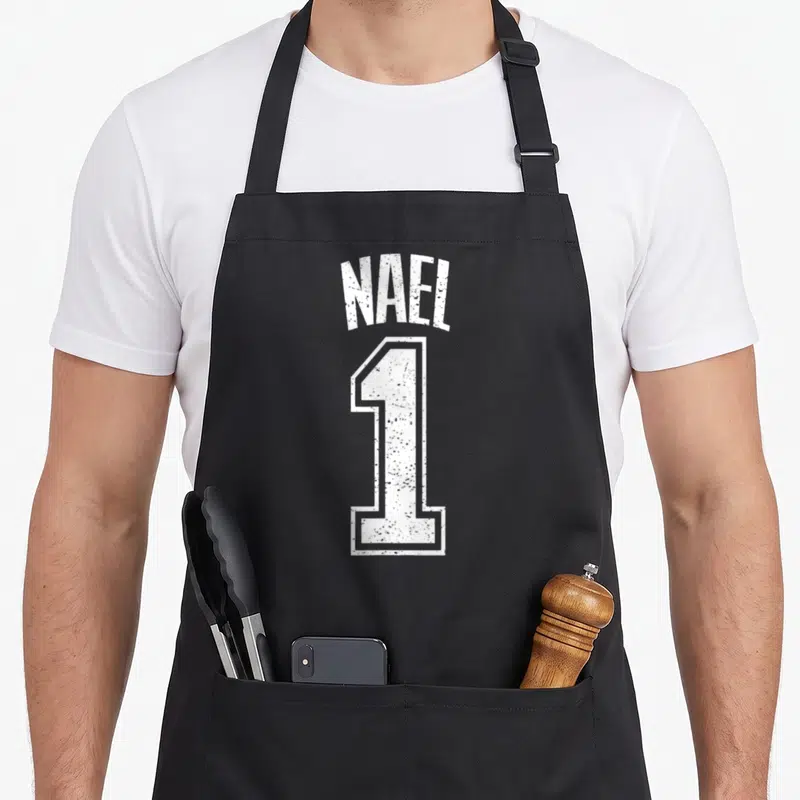 Tablier de cuisine noir avec l inscription Nael 1 en blanc style maillot de sport dégradé
