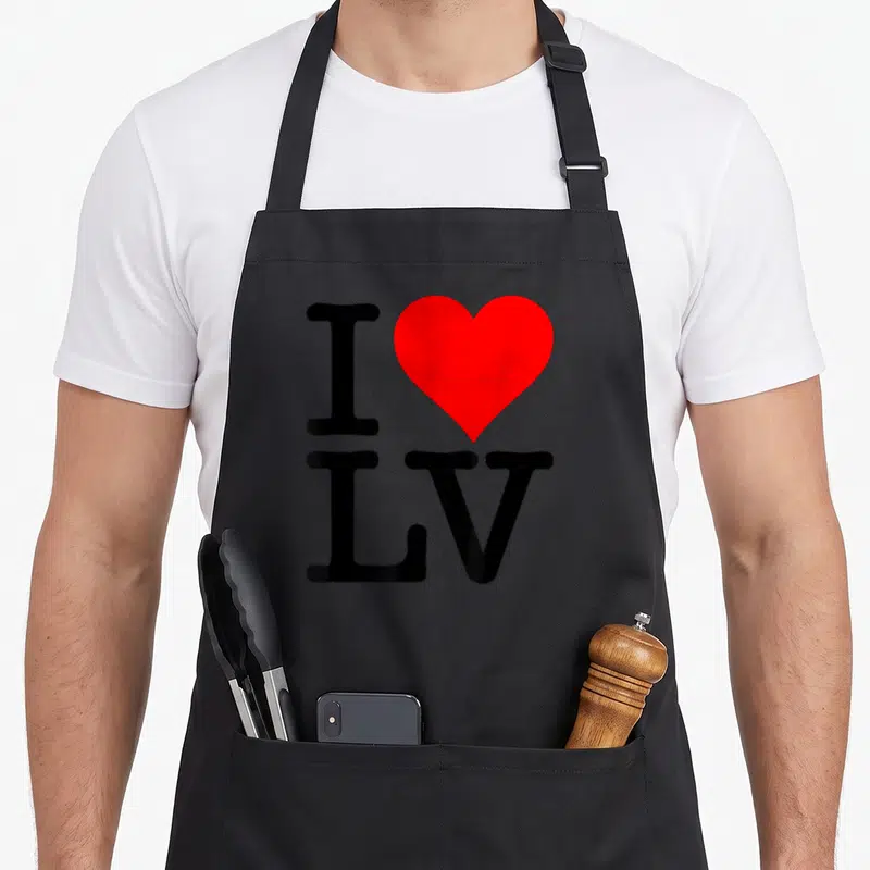Tablier de cuisine noir avec un grand cœur rouge et les lettres I LV imprimés en noir.