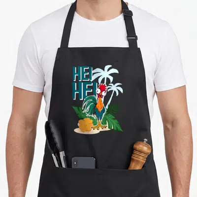 Tablier de cuisine noir avec illustration colorée du coq Hei Hei entouré de palmiers et d'une fleur orange sur fond tropical.