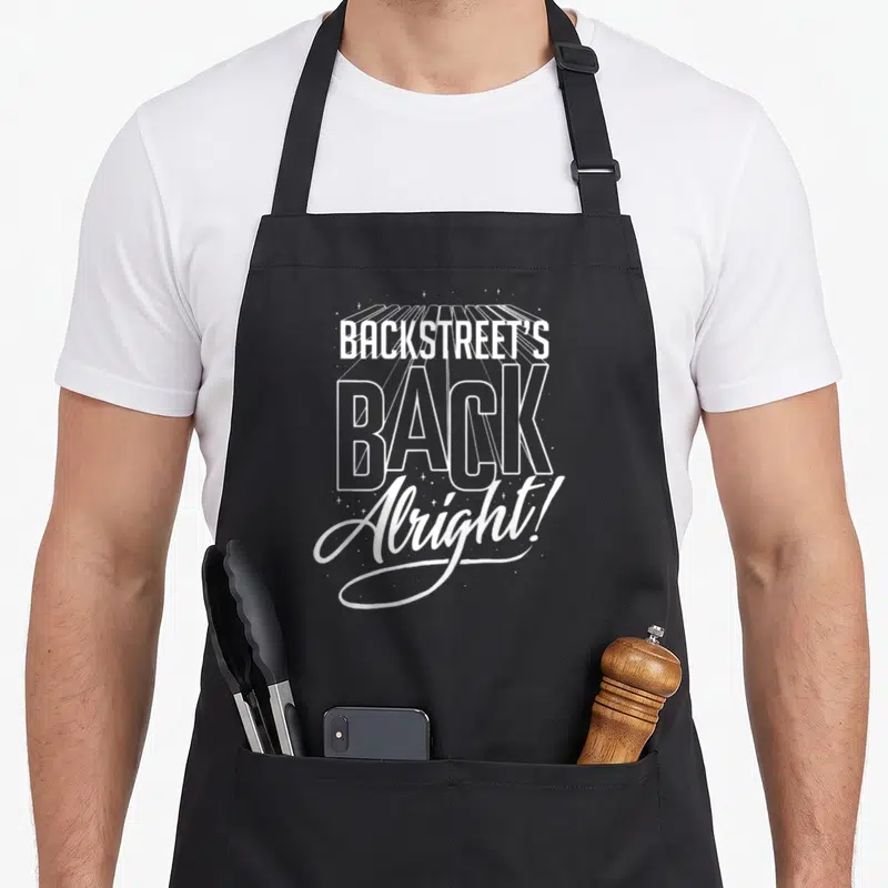 Tablier de cuisine noir avec le texte blanc Backstreet's Back et Alright. entouré d'étoiles cosmiques.