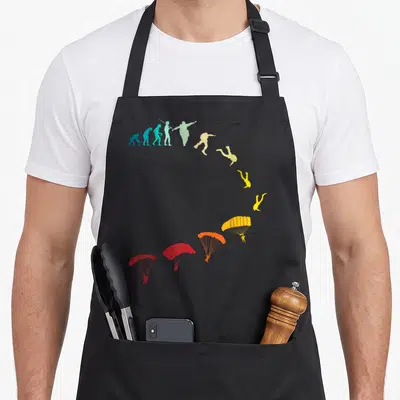 Tablier de cuisine noir avec illustration évolutive des silhouettes de parachutistes colorées en arc de cercle.