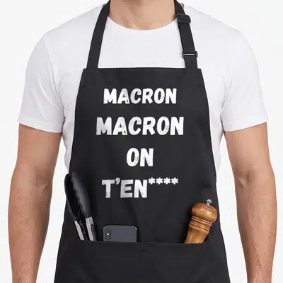 Tablier de cuisine noir avec l'inscription blanche Macron Macron on t'en **** en lettres capitales épaisses.