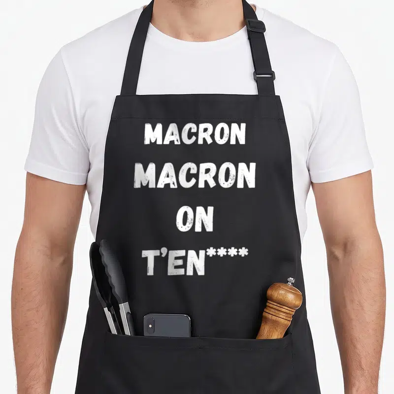 Tablier de cuisine noir avec l'inscription blanche Macron Macron on t'en **** en lettres capitales épaisses.