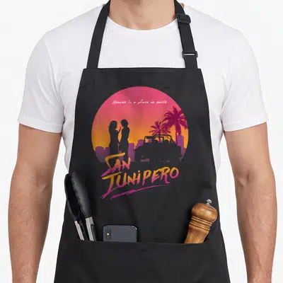 Tablier de cuisine noir avec illustration colorée de San Junipero et silhouettes de personnages face à face.