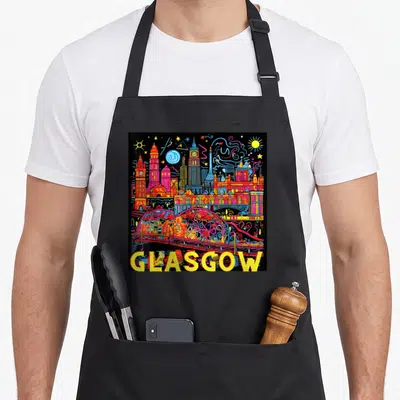 Tablier de cuisine noir avec une illustration Pop Art colorée de l'horizon de Glasgow et le nom GLASGOW en lettres jaunes en bas.