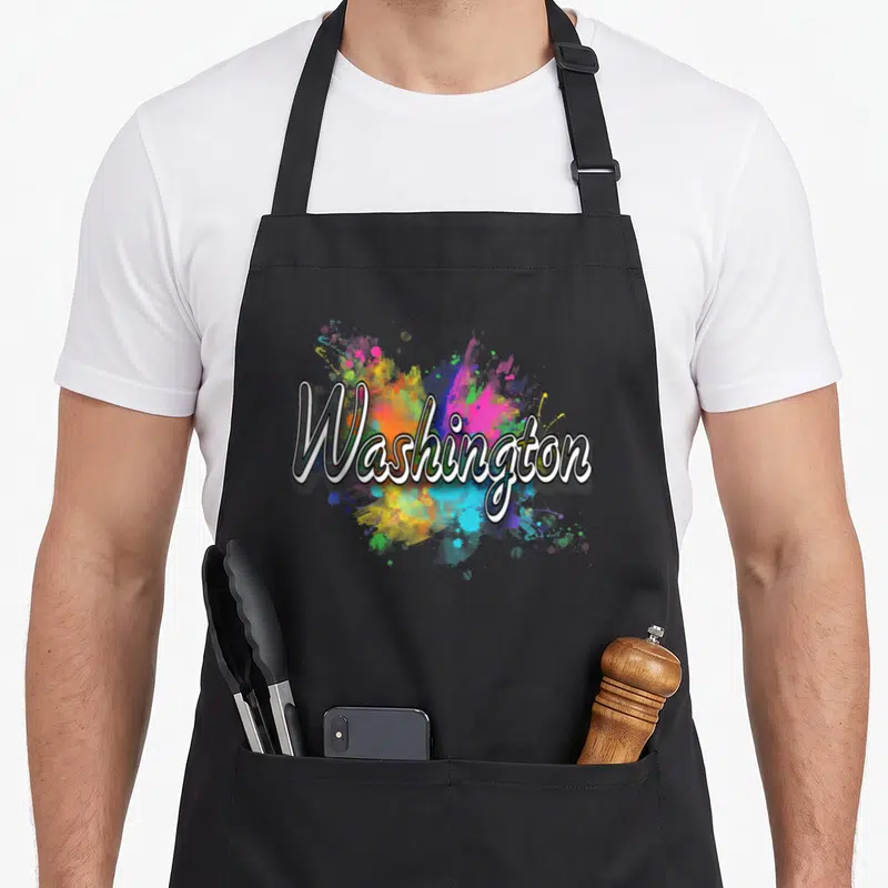 Tablier de cuisine noir avec l'inscription Washington en blanc sur un motif d'éclaboussures de couleurs vives.
