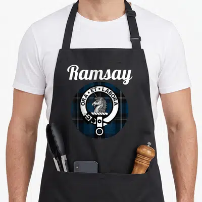 Tablier de cuisine noir avec le tartan Ramsay, un blason circulaire affichant une licorne et la devise Ora Et Labora en blanc.