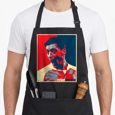 Tablier de cuisine noir avec portrait graphique rouge et bleu de Mesut Ozil et le texte INCOMPARABLE en bas.