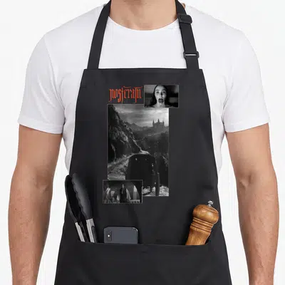 Tablier de cuisine noir avec collage photographique noir et blanc représentant un château et des personnages dans un style gothique.
