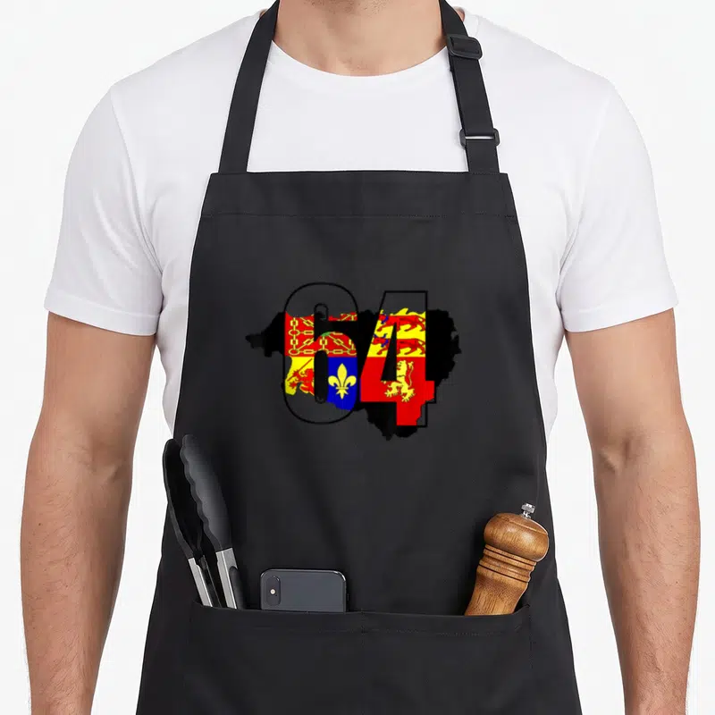 Tablier de cuisine noir avec le chiffre 64 et des armoiries régionales colorées superposées à une silhouette géographique.