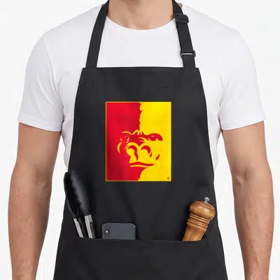 Tablier de cuisine noir avec le logo stylisé d'un gorille rouge sur fond jaune et rouge à gauche.