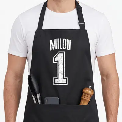 Tablier de cuisine noir avec l inscription Milou et le chiffre 1 en blanc style vintage sport.