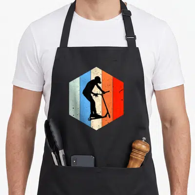 Tablier de cuisine noir avec une silhouette de trottinette freestyle sur fond hexagonal multicolore vintage.