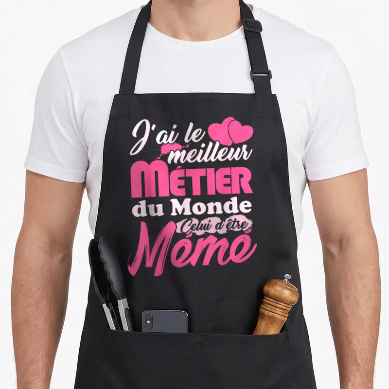 Tablier de cuisine noir avec inscription rose J'ai le meilleur métier du monde Mémé et deux cœurs.