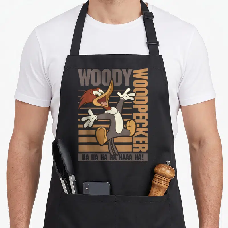 Tablier de cuisine noir avec illustration colorée de Woody Woodpecker sautant et texte Ha Ha Ha Haaa Ha en bas.