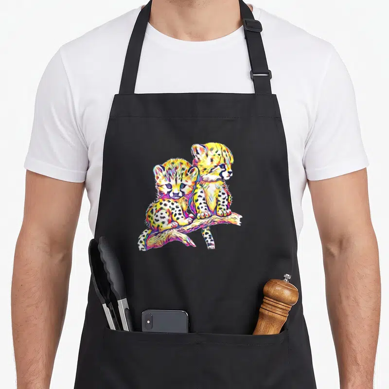 Tablier de cuisine noir avec deux guépards colorés assis sur une branche dans un style pop art.