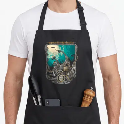 Tablier de cuisine noir avec illustration marine tentaculaire et texte a perfect circle en lettres dorées sur fond turquoise.
