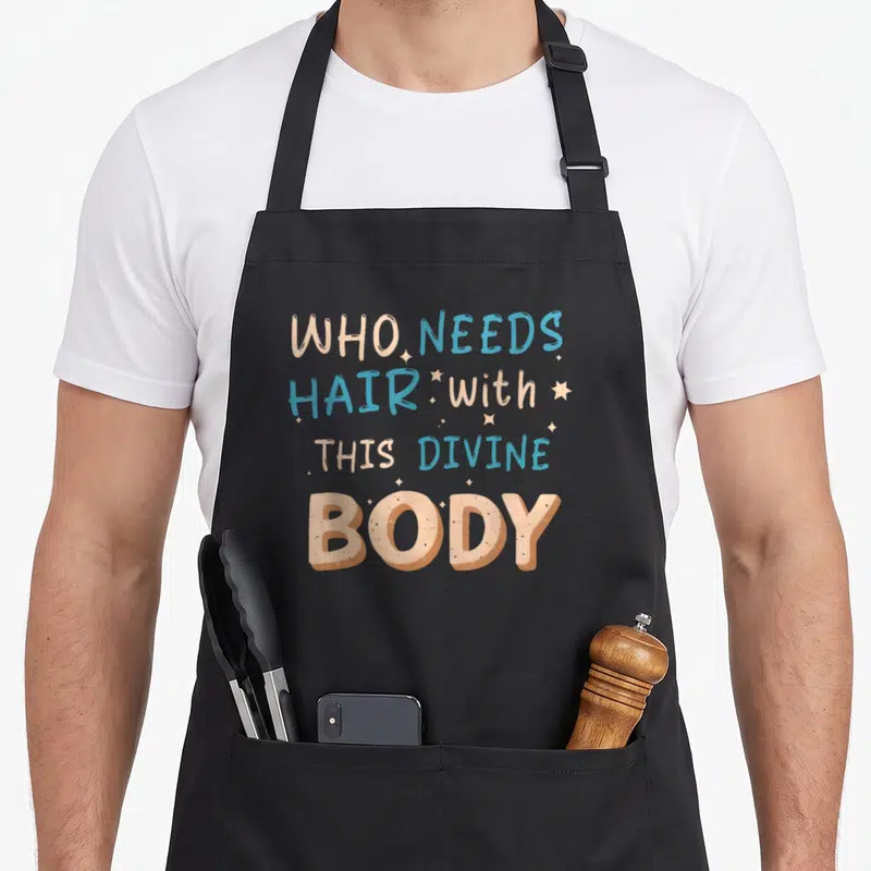 Tablier de cuisine noir avec le texte who needs hair with this divine body en lettres colorées et étoiles.