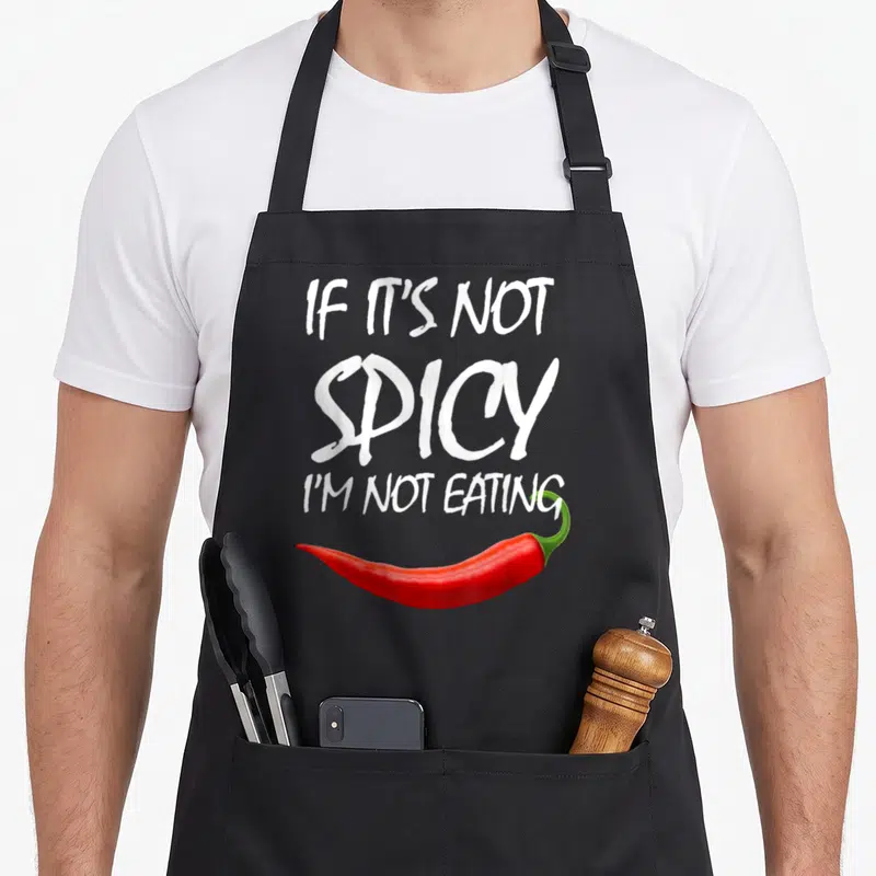 Tablier de cuisine noir avec une illustration de piment rouge et texte blanc If It's Not Spicy I'm Not Eating