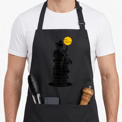 Tablier de cuisine noir avec une illustration de Don Quichote sur un moulin à vent fait de livres empilés.