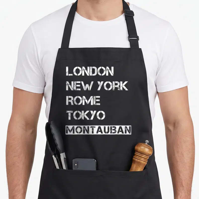 Tablier de cuisine noir avec les noms de grandes villes et Montauban en blanc au style pochoir délavé.