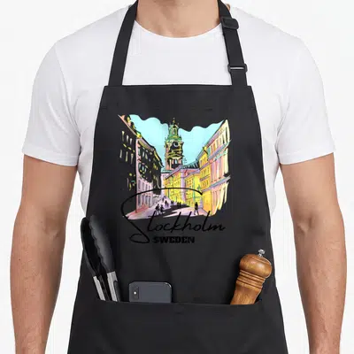 Tablier de cuisine noir avec illustration colorée d'une rue de Stockholm et l'inscription Stockholm Sweden en bas du motif.