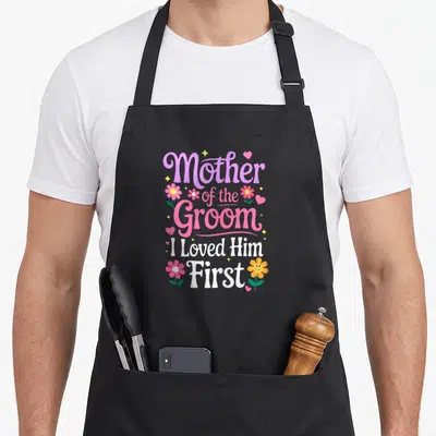 Tablier de cuisine noir avec inscription Mother of the Groom I Loved Him First et fleurs colorées.