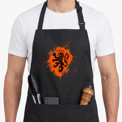 Tablier de cuisine noir avec un lion stylisé noir sur fond d'éclaboussure orange vif et le texte K.N.V.B.
