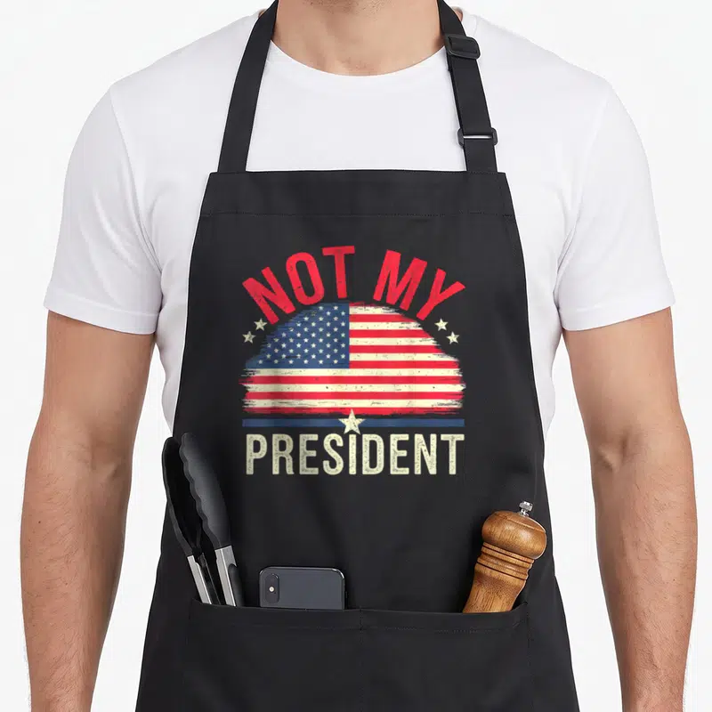 Tablier de cuisine noir avec drapeau américain et texte Ce n'est pas mon président en typographie vintage.