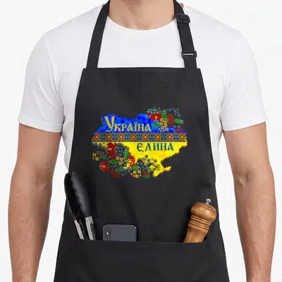 Tablier de cuisine noir avec une carte d'Ukraine stylisée en pixel art et motifs floraux colorés.