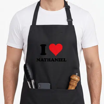 Tablier de cuisine noir avec un cœur rouge et le texte I NATHANIEL en lettres noires.