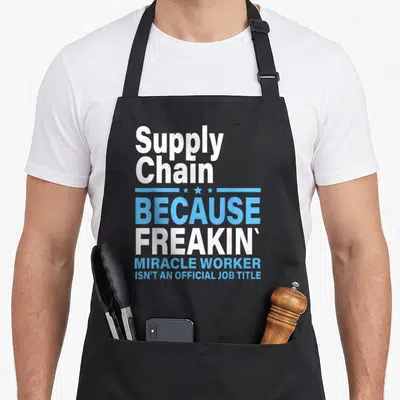 Tablier de cuisine noir avec texte blanc et bleu Supply Chain Because Freakin Miracle Worker.