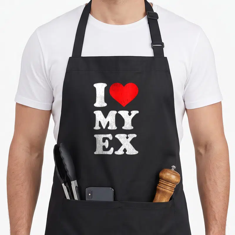 Tablier de cuisine noir avec inscription blanche J'aime mon ex et un cœur rouge stylisé au centre.