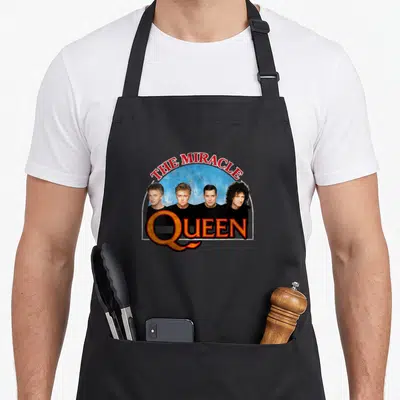 Tablier de cuisine noir avec illustration The Miracle Arch Queen et quatre portraits masculins sur fond bleu.