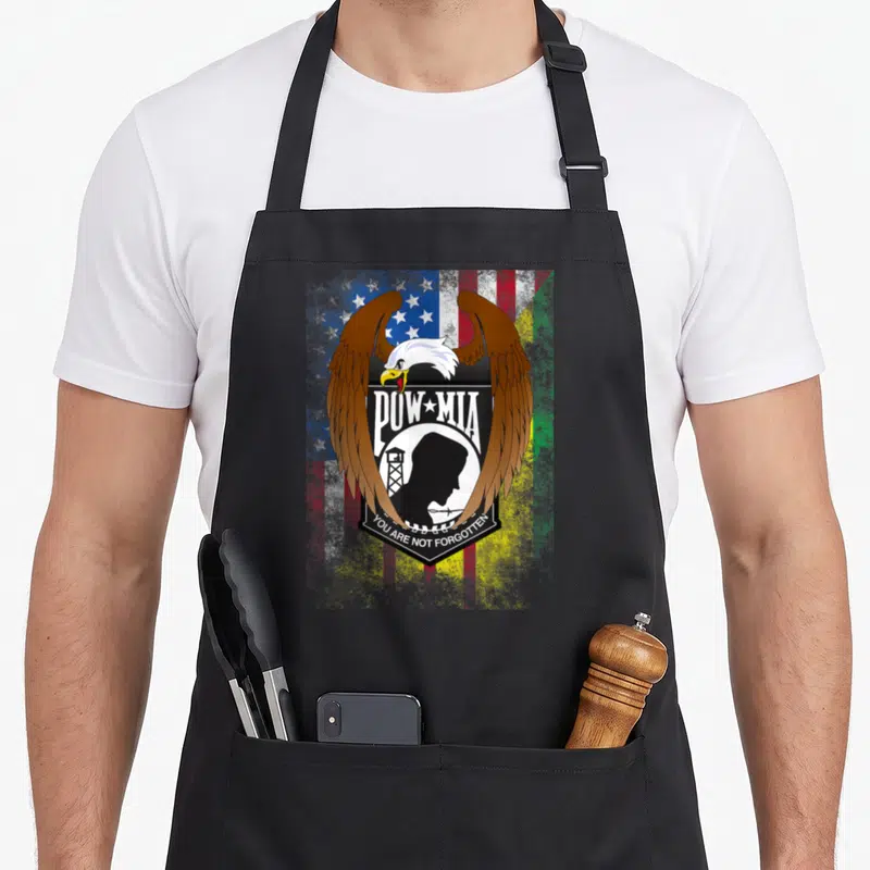 Tablier de cuisine noir avec un aigle aux ailes déployées et le texte POW MIA vous n'êtes pas oublié.