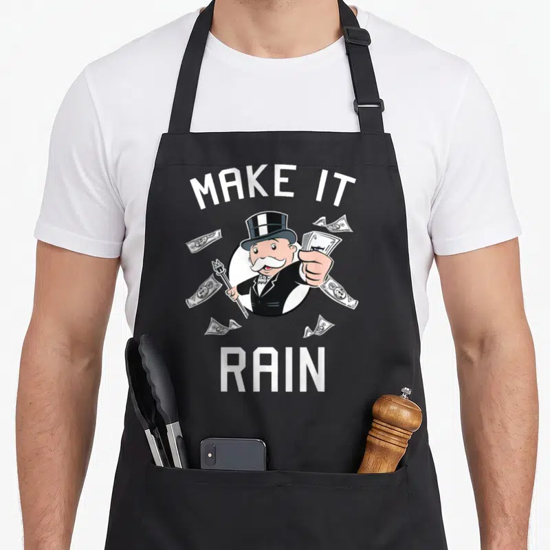 Tablier de cuisine noir avec illustration d'un homme en chapeau haut de forme tenant une fourche et des billets de banque.