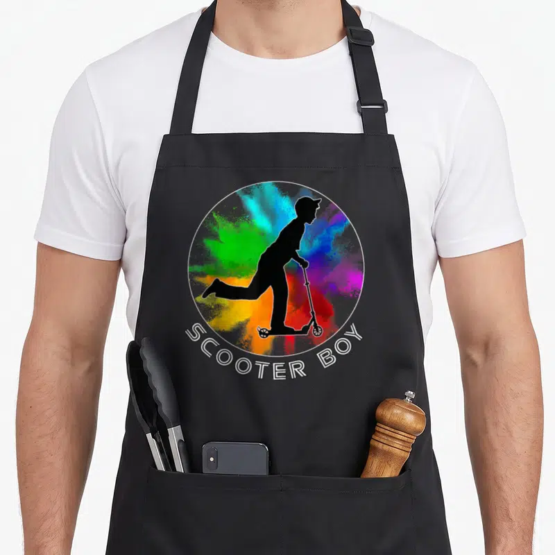 Tablier de cuisine noir avec une trottinette en silhouette noire sur fond de poudre colorée et l'inscription Scooter Boy.