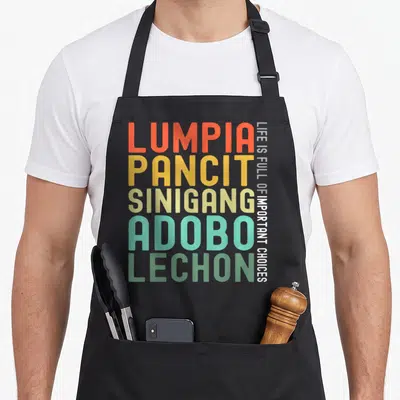 Tablier de cuisine noir avec typographie colorée listant Lumpia Pancit Sinigang Adobo Lechon en lettres majuscules verticales.