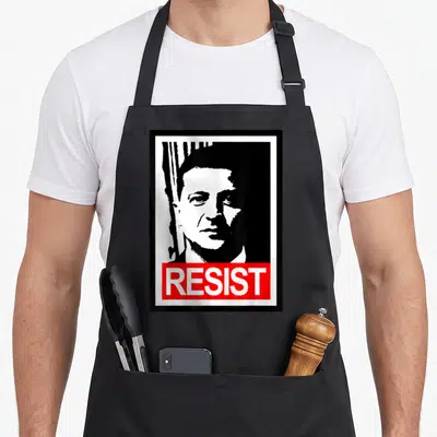 Tablier de cuisine noir avec portrait stylisé en noir et blanc et bande rouge portant le mot RESIST en lettres capitales blanches.