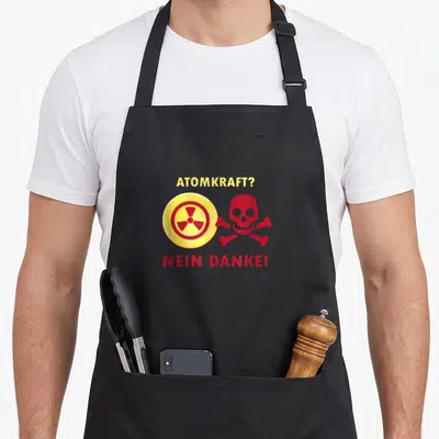 Tablier de cuisine noir avec le texte Atomkraft Nein Danke et un crâne rouge à côté d'un symbole de radiation jaune.