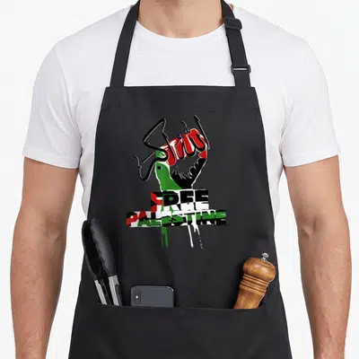 Tablier de cuisine noir orné d'un poing levé aux couleurs palestiniennes et du texte Free Palestine Libre en typographie graffiti.