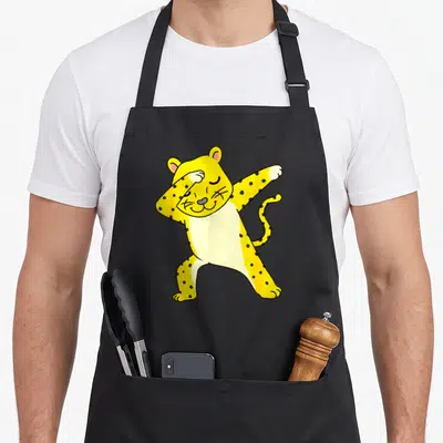 Tablier de cuisine noir avec un guillemés de guillemets jaune à pois effectuant une pose dab stylisée et souriante.