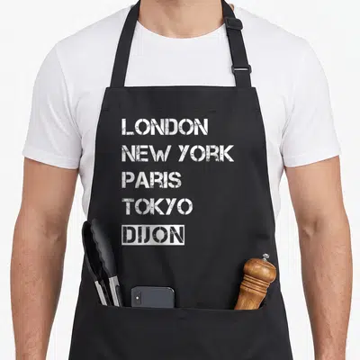 Tablier de cuisine noir avec une liste de villes en lettres blanches dont Dijon est encadré en bas.