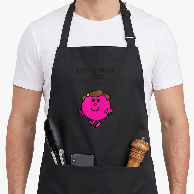 Tablier de cuisine noir avec l'illustration rose de Little Miss Wise et la signature de l'artiste au-dessus.