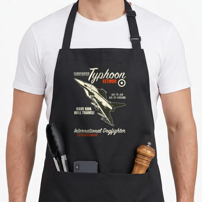 Tablier de cuisine noir avec illustration d'un avion de chasse Eurofighter Typhoon EF2000 et textes en blanc et orange.